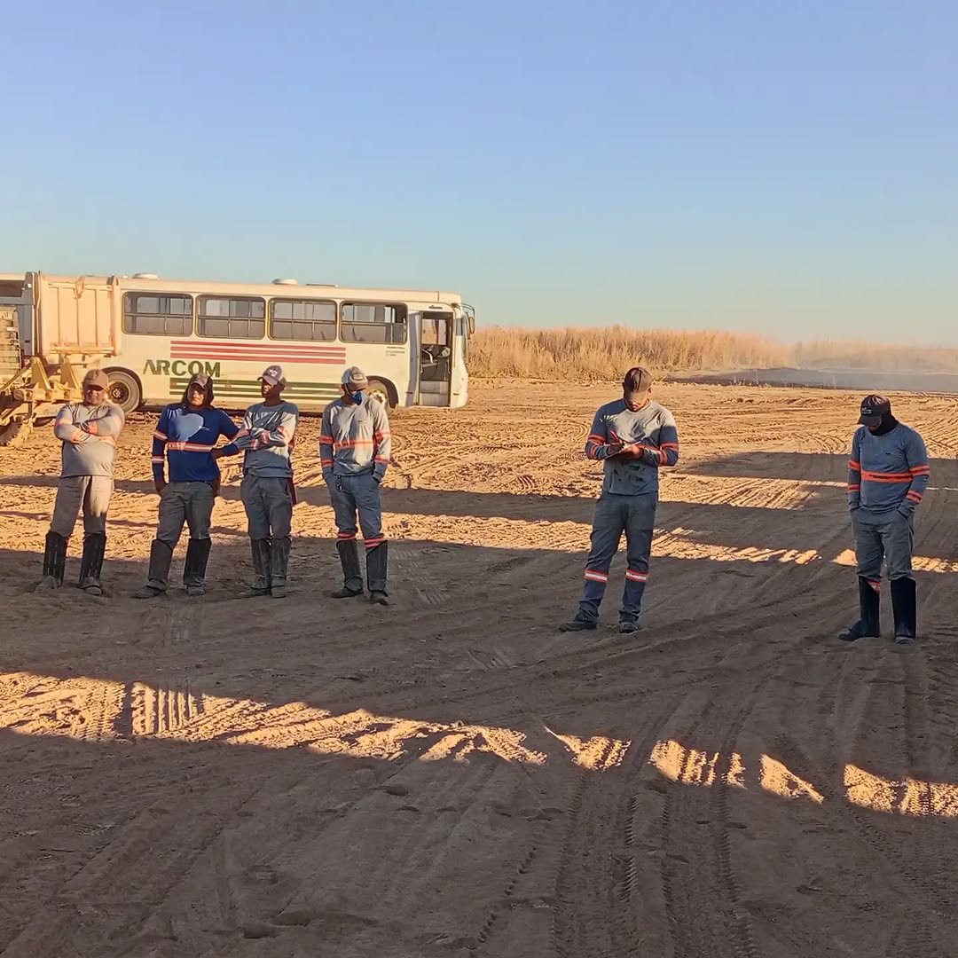 Trabalhadores reunidos em área de trabalho no campo